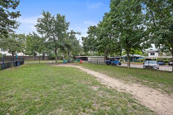 a grassy area with trees and a fence at Artisan Apartments & Shops, Austin